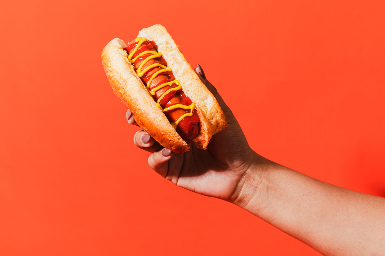 Conceptual Food Delivery Hand Holding a Hotdog